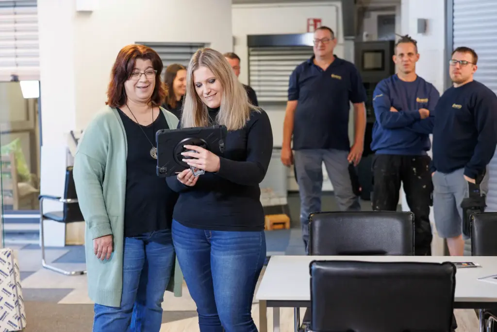 Fotos zur Mitarbeitergewinnung - Teamfoto während der Arbeit - Beziehung zwischen Büro und Produktion