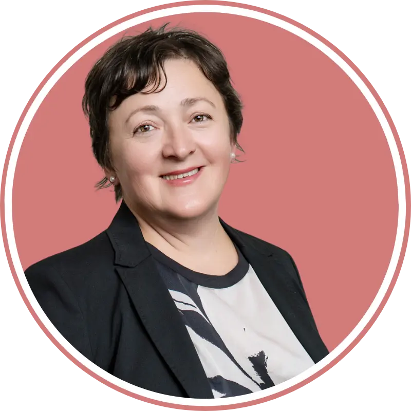 Authentisches Business-Foto einer Frau mit rötlich-rosafarbenem Hintergrund und freundlichem Ausdruck.