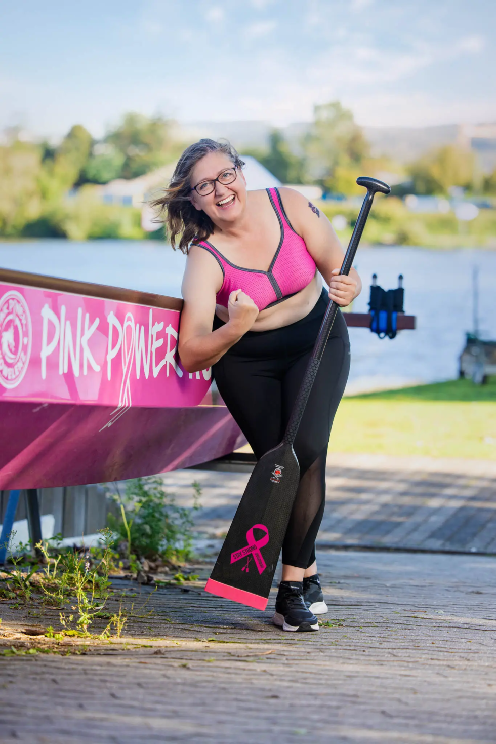 Bettina mit Paddel vor dem Boot Pink Power – Pink Paddler Koblenz Fotokampagne Brustkrebs Sichtbarkeit