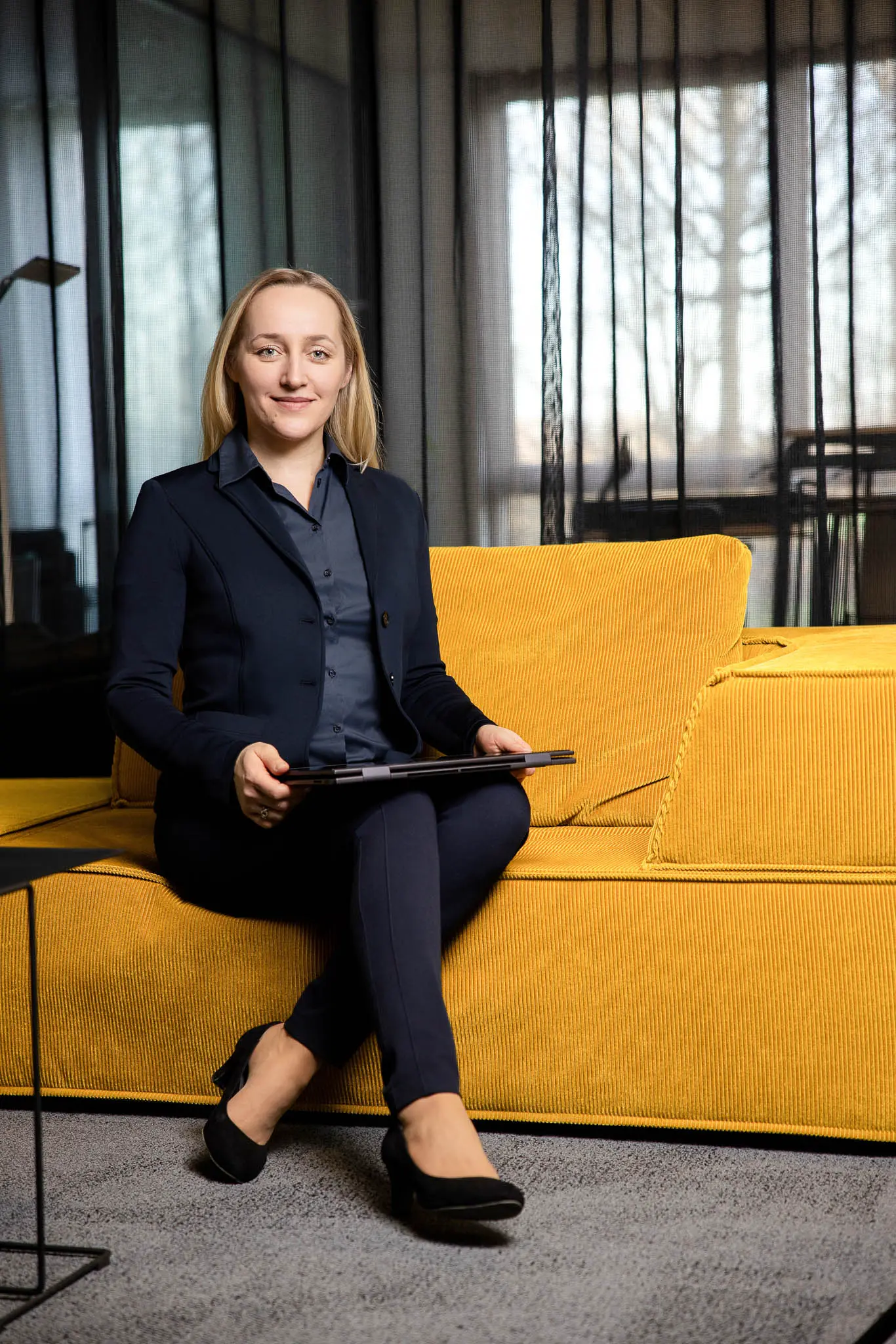 Valeria de Graaff. Social Media Beraterin, in moderner Atmosphäre mit Laptop auf einer gelben Couch. fotografiert von Markenfotografin in Polch bei Koblenz, Karina Schuh