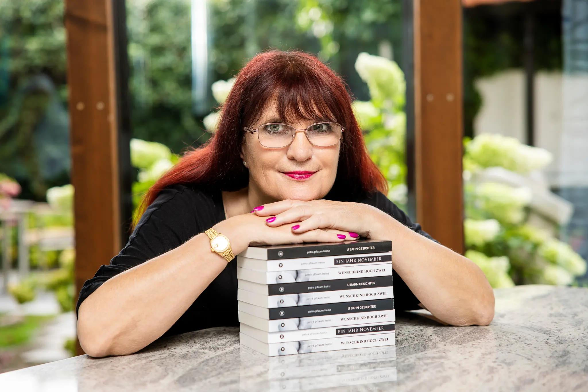 Petra Pflaum-Heinz, Romanautorin, mit einem Stapel ihrer Bücher — Personal Branding Fotografie von Karina Schuh, Markenfotografin Koblenz