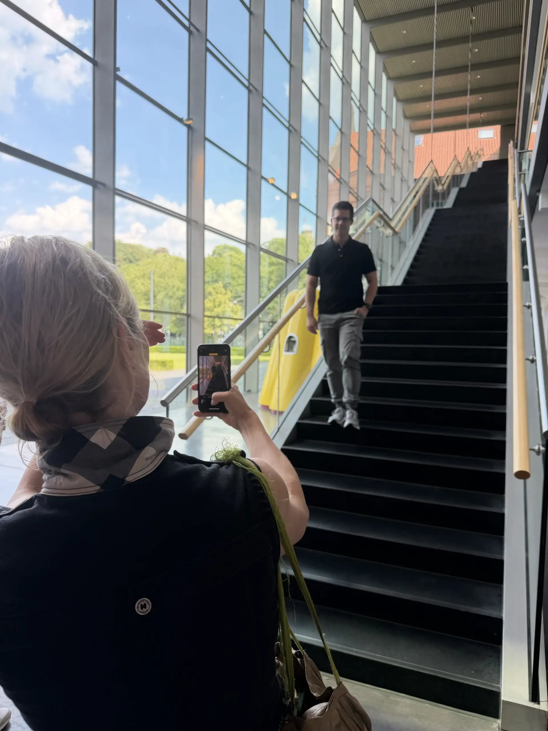 Teilnehmerin übt Smartphone-Fotografie auf der Treppe des Dr. Oetker Campus beim Corporate Influencer Workshop