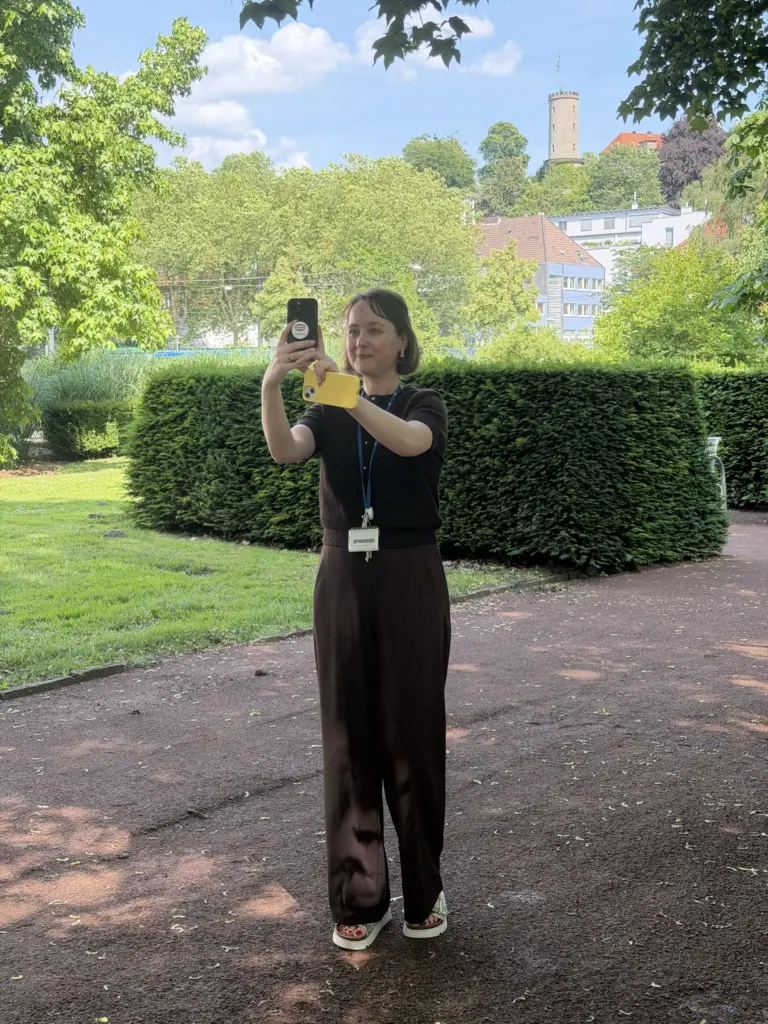 Teilnehmerin macht Selfie im Freien auf dem Dr. Oetker Campus Bielefeld beim Corporate Influencer Workshop