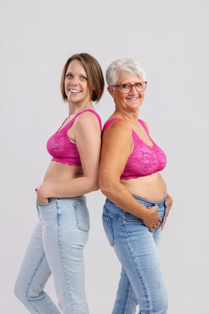 Zwei lachende Frauen in pinken BHs und Jeans stehen Rücken an Rücken, Pinktober Koblenz 2026
