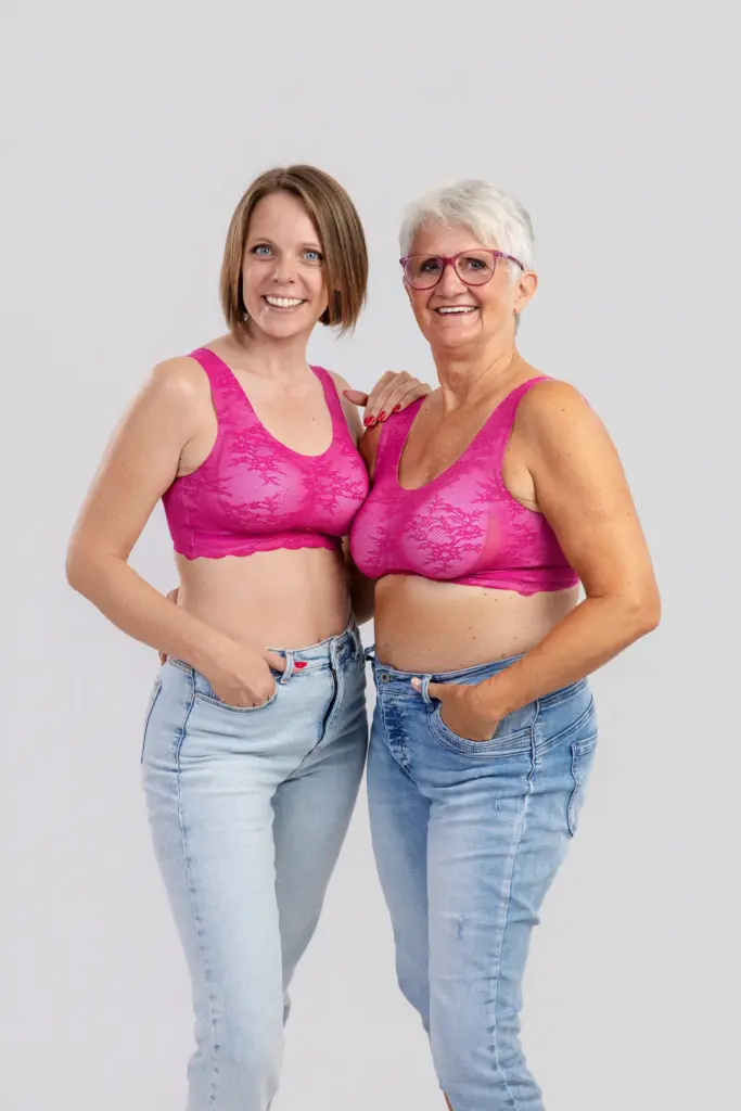 Zwei strahlende Frauen in pinken BHs und Jeans stehen eng nebeneinander, Pinktober Koblenz 2026