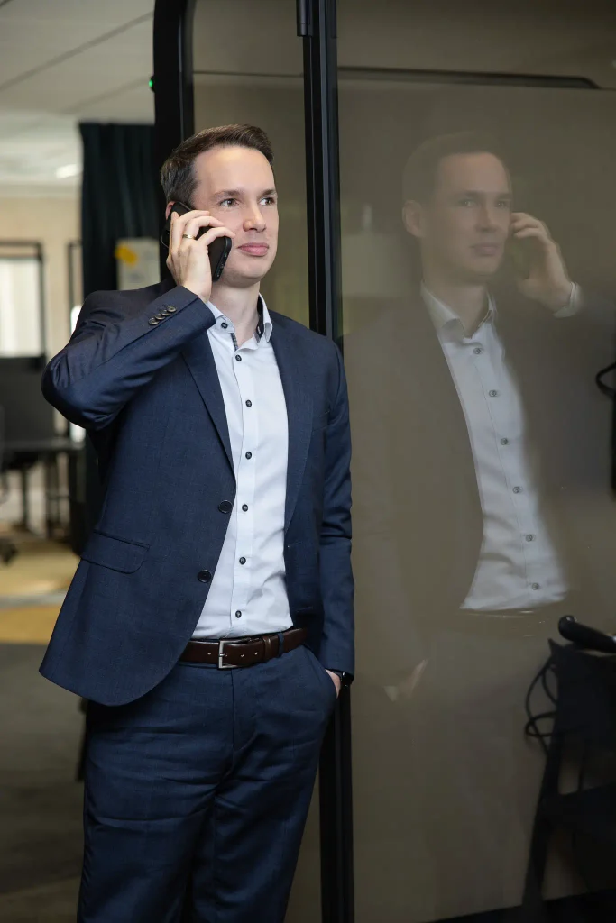 Steuerberater Tobias Junges im Anzug mit Spiegelung in der Glasscheibe bei designfunktion, Foto für die Website