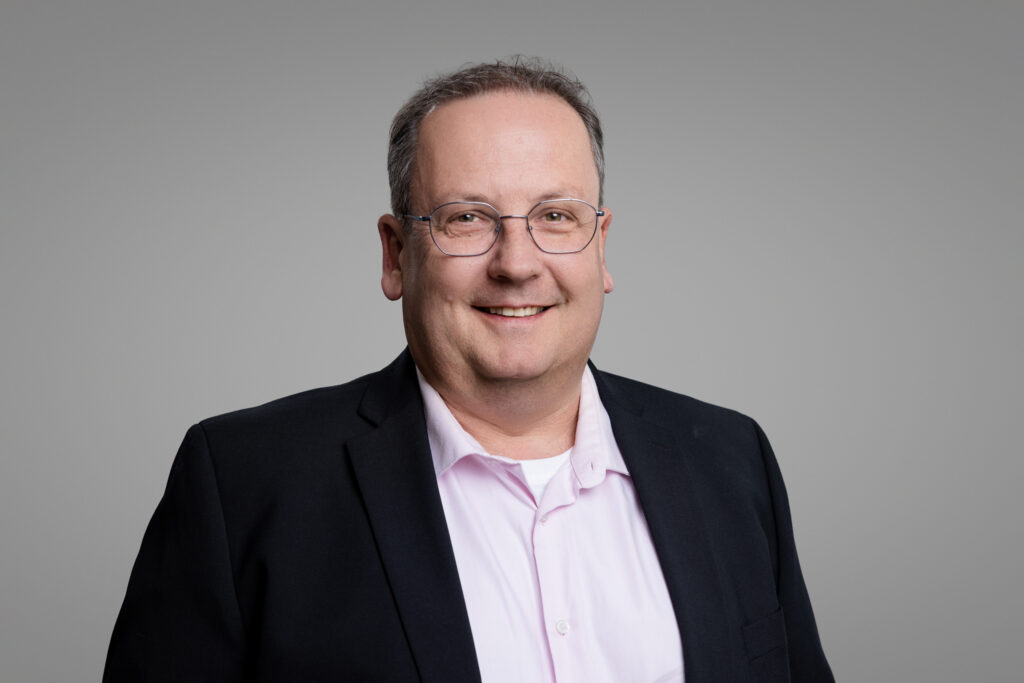 Business Portrait von Führungskraft vor grauem Hintergrund