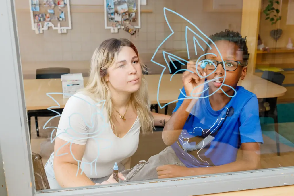 Erzieherin mit Kind beim Windowcolor im St. Vinzenzhaus Einrichtung der Kinder- und Jugendhilfe