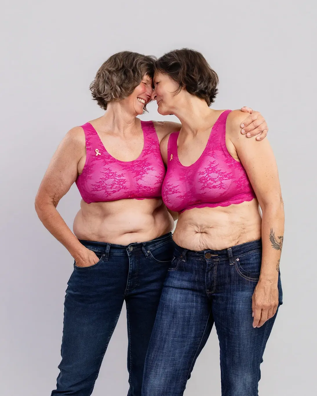 Zwei Frauen im pinken BH, Stirn an Stirn, beim Fotoshooting für Frauen mit Krebs in Koblenz